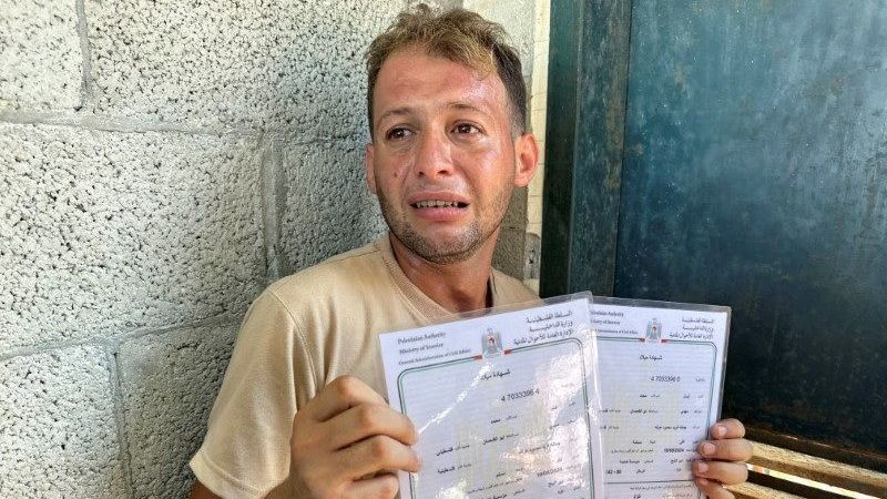 Palestino mostra certidões de filhos recém-nascidos mortos em Deir Al-Balah