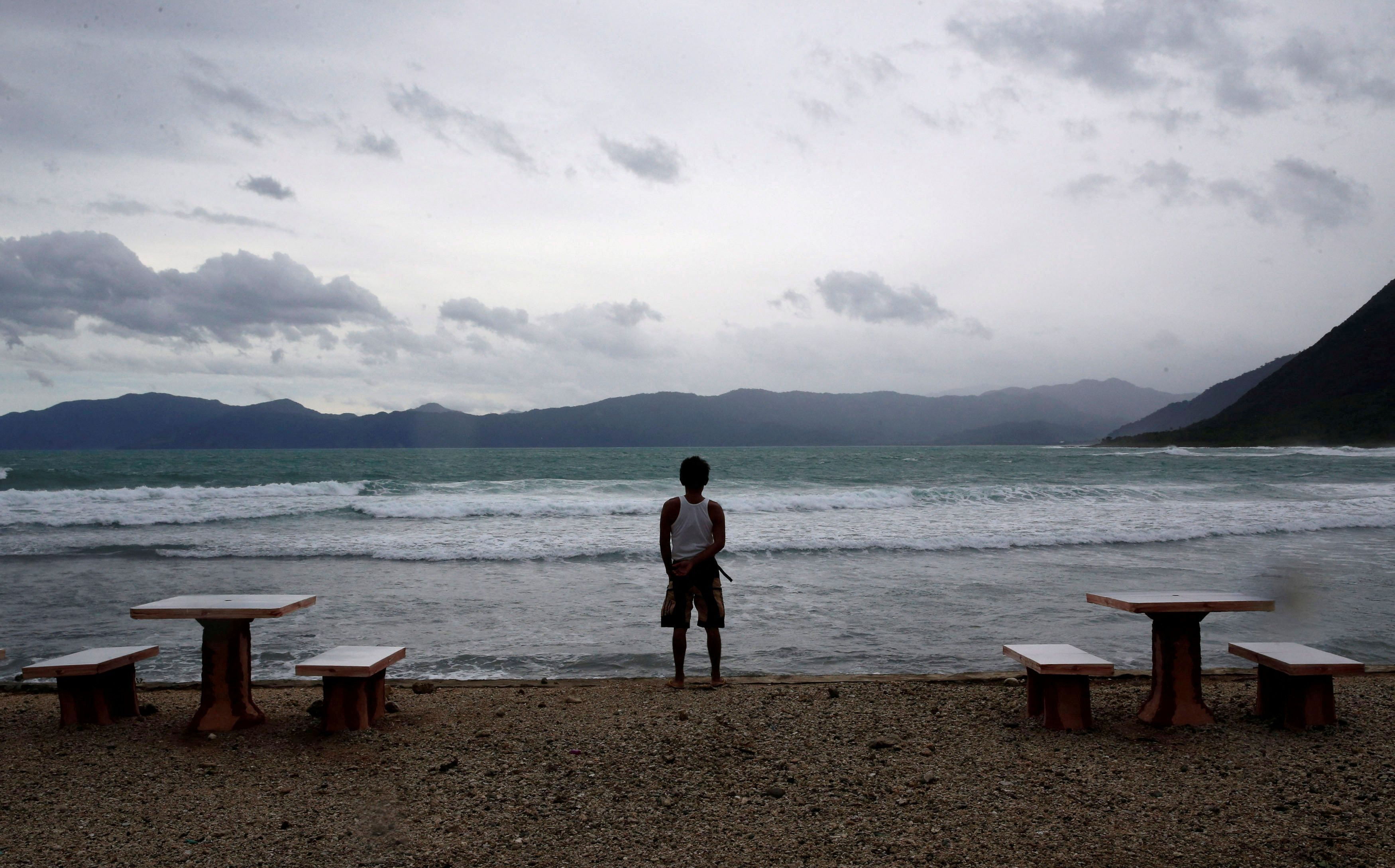 Um funcionário olha para a praia de um resort vazio enquanto o tufão Haima atinge Pagudpud, Ilocos Norte, no norte das Filipinas