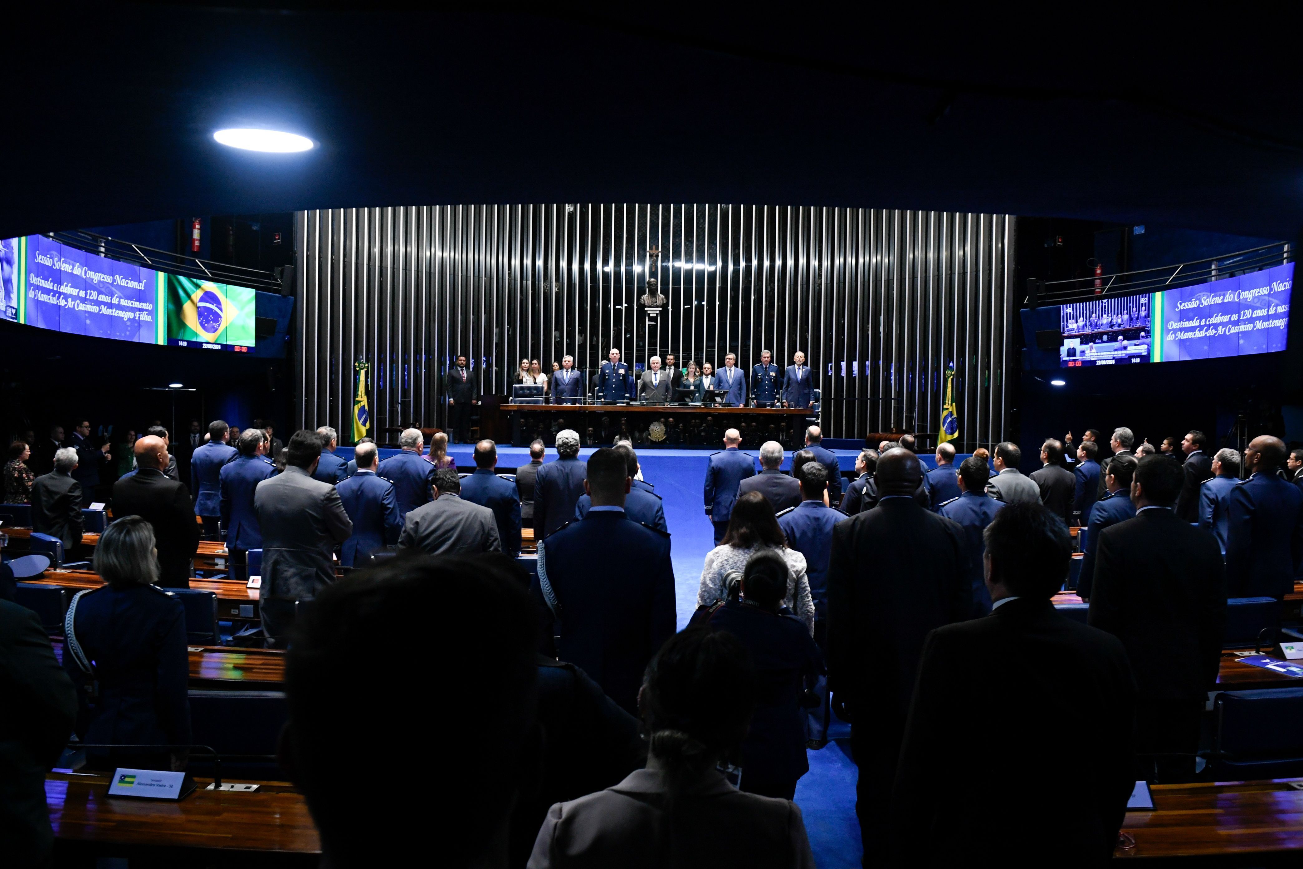 Plenário do Senado Federal durante sessão solene destinada a celebrar os 120 anos de nascimento do marechal-do-ar Casimiro Montenegro Filho. Em posição de respeito, parlamentares e convidados acompanham execução do Hino Nacional pela Banda da Base Aérea de Brasileira (FAB). Mesa: senador Izalci Lucas (PL-DF); comandante da Aeronáutica, tenente-brigadeiro do ar Marcelo Kanitz Damasceno; presidente e requerente desta sessão, senador Astronauta Marcos Pontes (PL-SP); diretora da Secretaria Legislativa do Congresso Nacional, Roberta Lys de Moura Rochael; requerente desta sessão, deputado Danilo Forte (União-CE); diretor-geral do Departamento de Ciência e Tecnologia Aeroespacial (DCTA), tenente-brigadeiro do ar Maurício Augusto Silveira de Medeiros; secretário de Ciência e Tecnologia para o Desenvolvimento Social (Sedes) do Ministério da Ciência Tecnologia e Inovação (MCTI), Inácio Arruda. Foto: Jefferson Rudy/Agência Senado