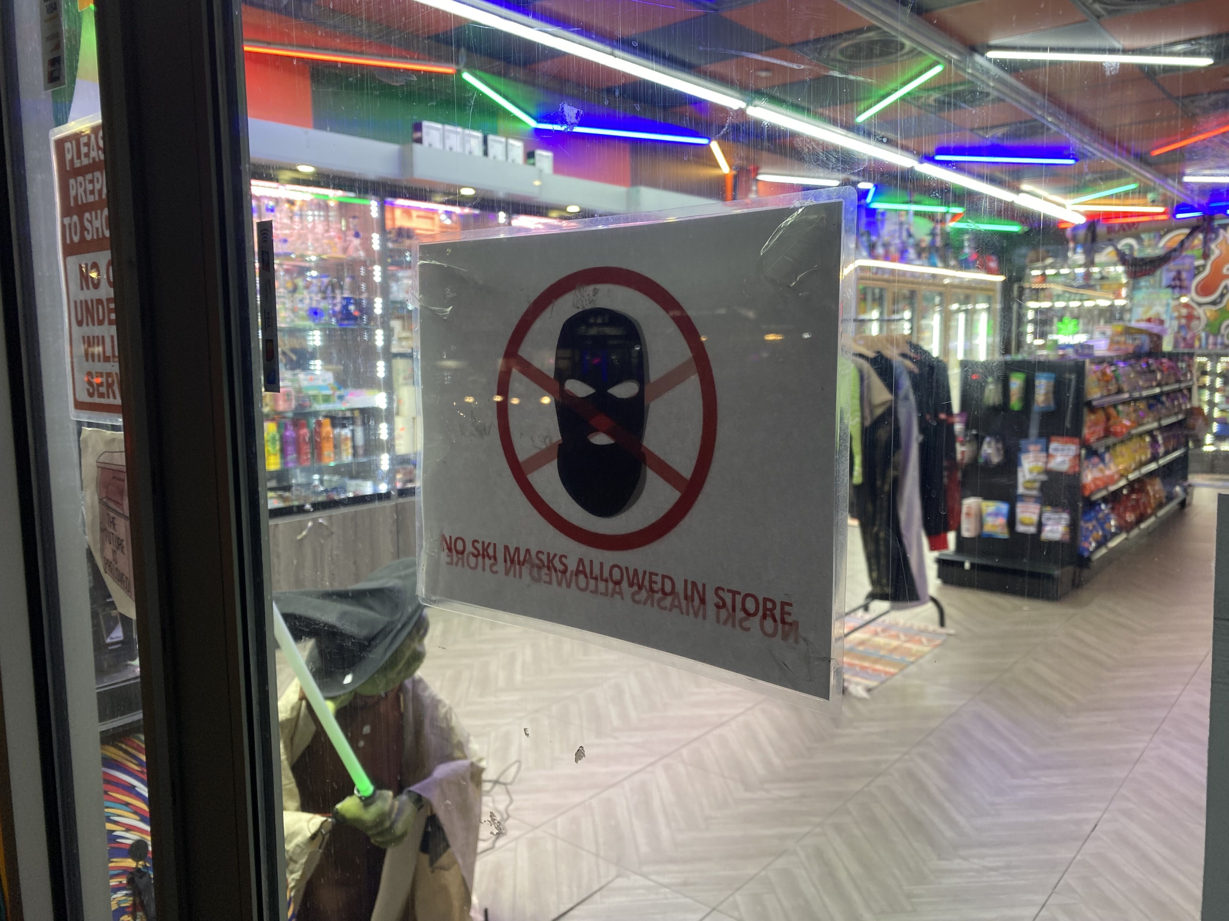 No Ski Masks Allowed sign in doorway of Marijuana convenience store in Queens, New York