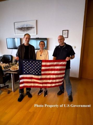 O repórter do Wall Street Journal Evan Gershkovich, a jornalista da Radio Free Europe Alsu Kurmasheva e o ex-fuzileiro naval dos EUA Paul Whelan posam com uma bandeira americana no saguão do aeroporto em 1º de agosto de 2024 em Ancara, Turquia / Governo dos EUA/Getty Images