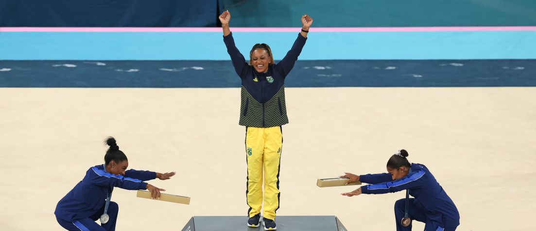 Simone Biles e Jordan Chiles reverenciam Rebeca Andrade no pódio do solo em Paris 2024 • Elsa/Getty Images