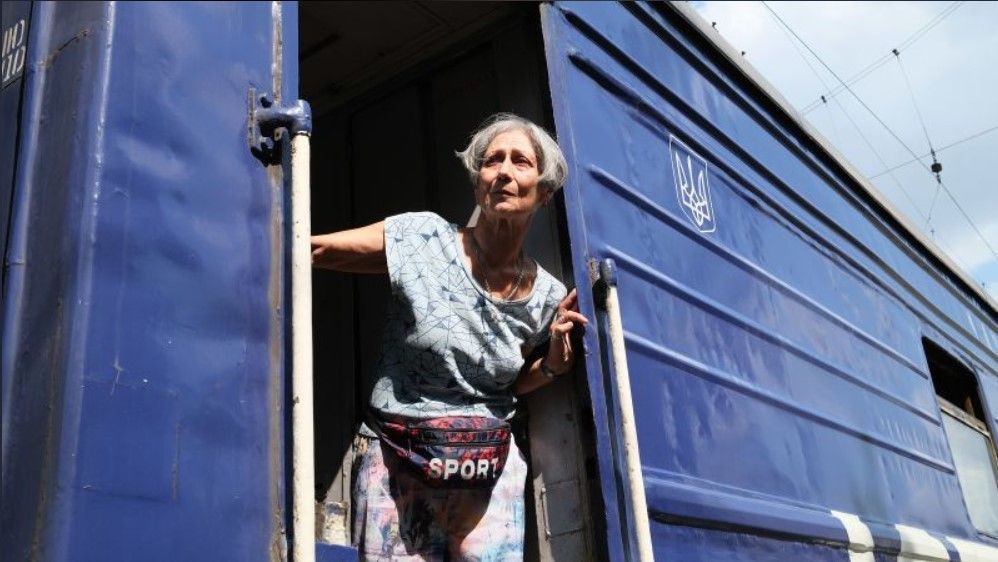 Ucraniana olha para fora do trem de retirada fugindo da Ucrânia