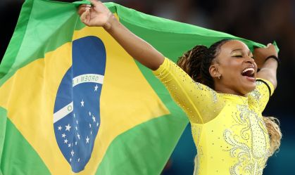 Rebeca Andrade comemora o segundo lugar após disputa com a lenda Simone Biles