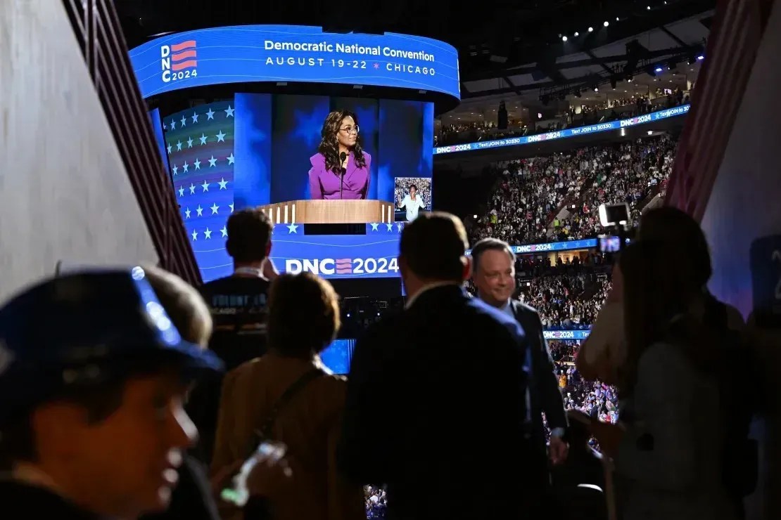 Pessoas assistem Oprah Winfrey falar na Convenção Nacional Democrata em Chicago em 21 de agosto de 2024 • Austin Steele/CNN
