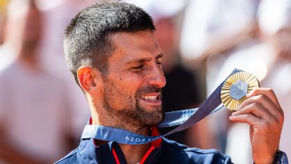 Novak Djokovic olha para a medalha de ouro que conquistou na Olimpíada de Paris