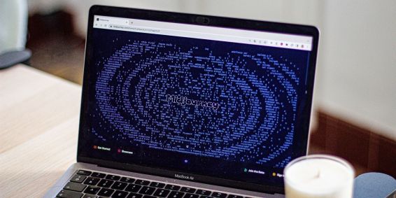 Uma fotografia de um computador com a tela na página inicial da inteligência artificial Midjourney.