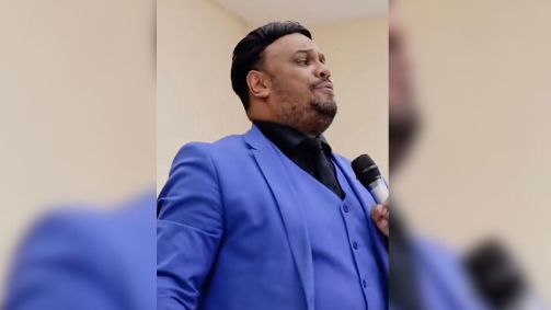 Diego Reis (Republicanos) veste terno azul e segura microfone