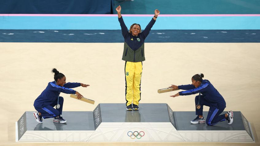 Simone Biles e Jordan Chiles reverenciam Rebeca Andrade no pódio do solo em Paris 2024 • Elsa/Getty Images