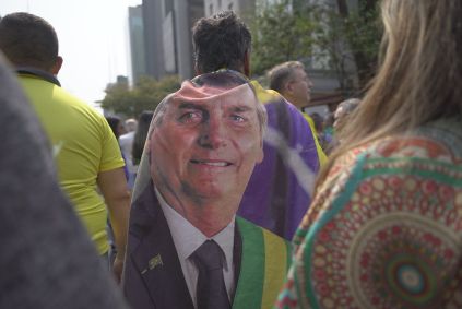 Manifestante veste capa com o rosto do ex-presidente da República Jair Bolsonaro