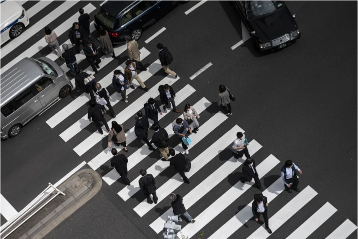 Pedestres, incluindo funcionários de escritório, atravessam uma rua na área de Shimbashi, em Tóquio, na hora do almoço, em 1º de abril de 2021. • Charly Triballeau/AFP/Getty Images