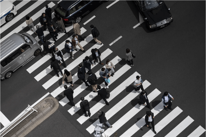 Pedestres, incluindo funcionários de escritório, atravessam uma rua na área de Shimbashi, em Tóquio, na hora do almoço, em 1º de abril de 2021. • Charly Triballeau/AFP/Getty Images
