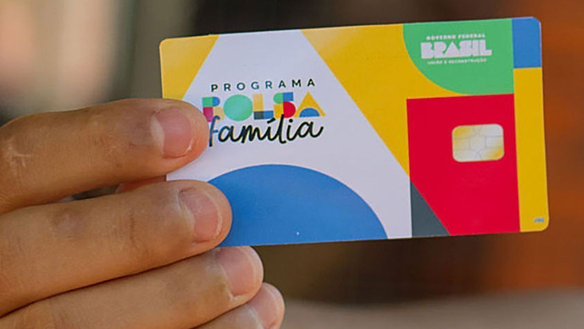 Pessoa segurando cartão do programa bolsa família