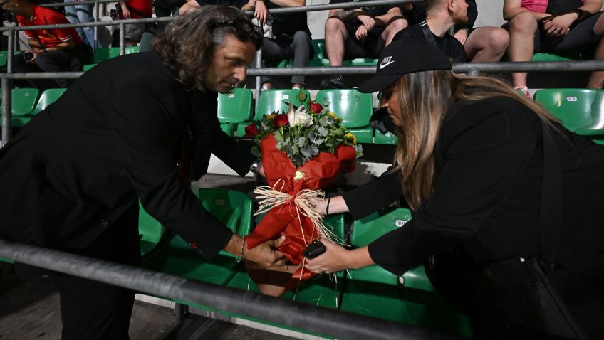 Representantes de Liverpool e Milan botam um buquê de flores na cadeira onde sentaria o torcedor que morreu na véspera do jogo • Andrew Powell/Liverpool FC via Getty Images
