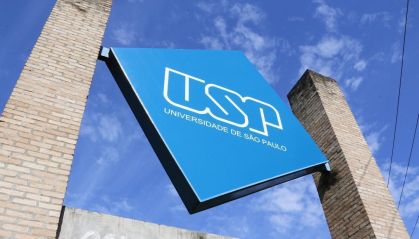 A foto mostra uma grande placa azul escrito USP