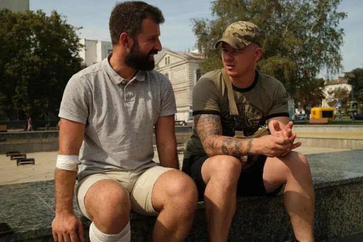 Dmytro (à direita), o comandante do batalhão “Nightingale” da Ucrânia, visita Vasyl, um membro do batalhão que foi ferido na Rússia • Ivana Kottasova/CNN