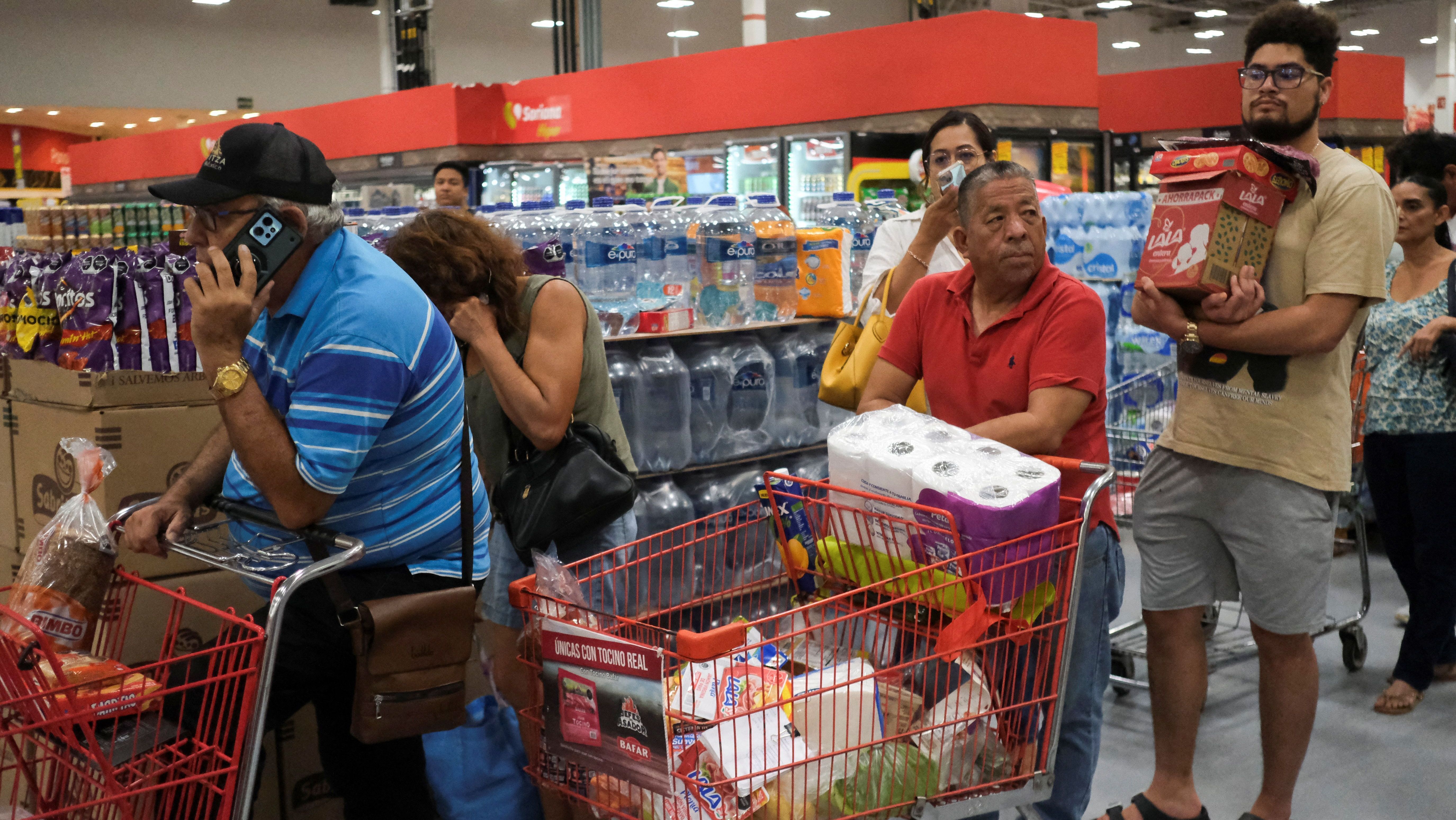 Pessoas fazem fila para comprar comida e suprimentos em supermercado de Cancún, no México, antes da passagem do furacão Milton
