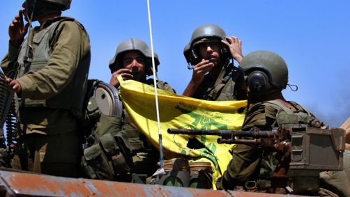 Soldados israelenses mostram uma bandeira do Hezbollah quando voltam da ação contra os guerrilheiros do Hezbollah no sul do Líbano, 25 de julho de 2006, na fronteira israelo-libanesa, perto da comunidade de Avivim.