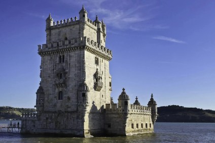 torre com tijolos cinzas e pequenas torres no andares mais baixos