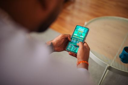 Pessoa usa smartphone para apostas esportivas