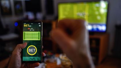 Pessoa usa smartphone para apostas esportivas