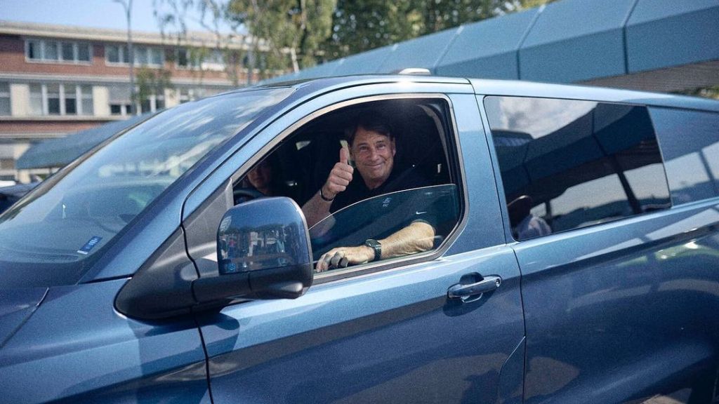 O CEO da Ford, Jim Farley, dirige um carro da empresa e acena para fotógrafos
