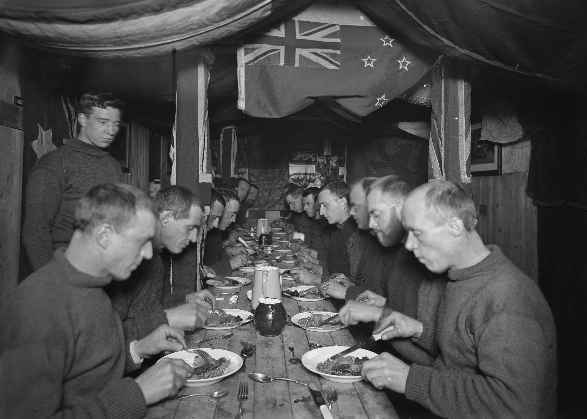 A tripulação do Endurance fazendo uma refeição a bordo, quatro meses antes de serem forçados a abandonar o navio • Falklands Heritage Maritime Trust/National Geographic via CNN Newsource