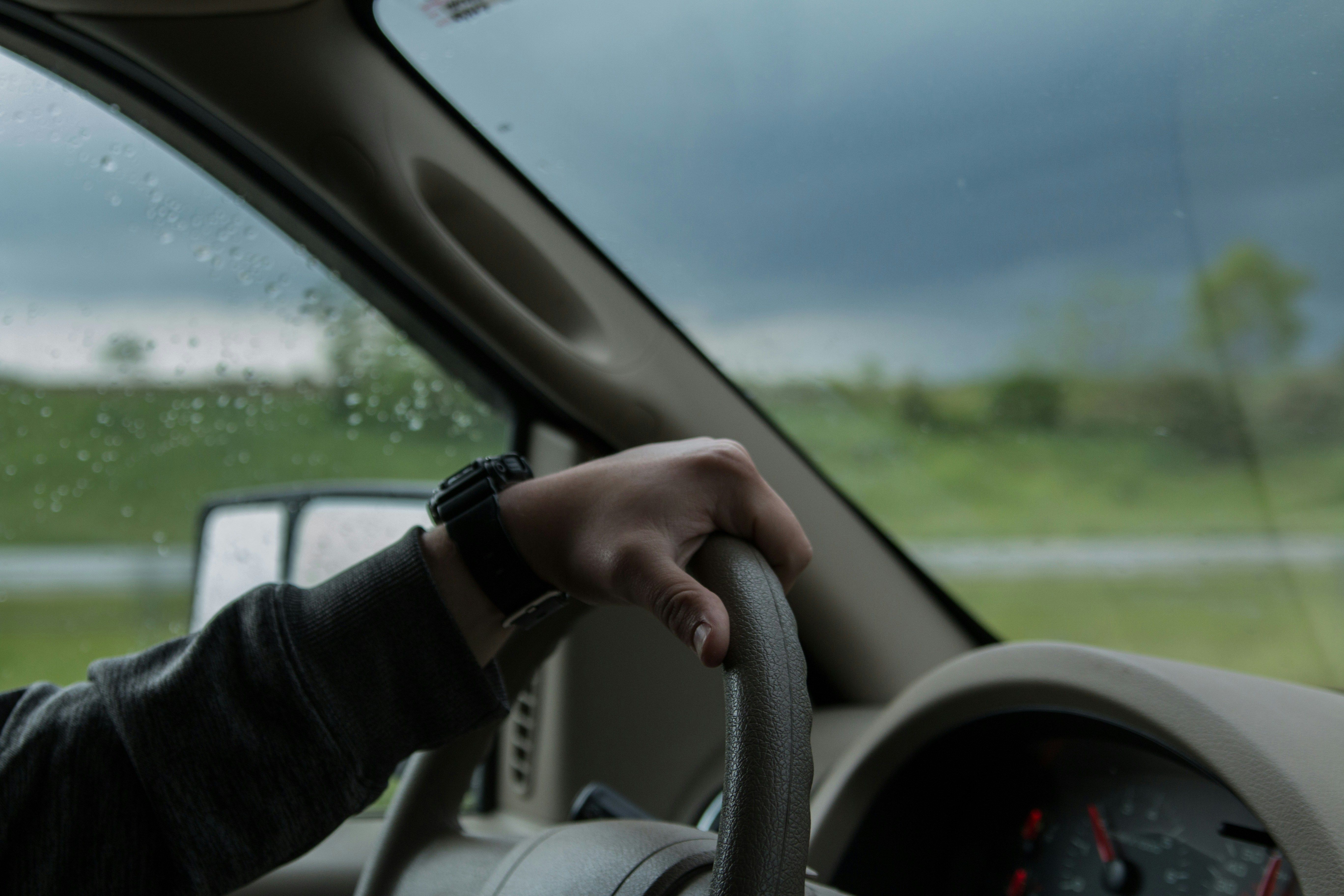 pessoa dirigindo segurando volante carro veículo