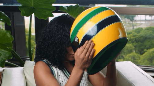 Rebeca Andrade com o capacete que permite ouvir a voz de Ayrton Senna