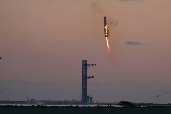 O foguete propulsor Super Heavy da SpaceX retorna à plataforma de lançamento para ser capturado pelos "hashis" de Mechazilla durante um voo de teste em 13 de outubro • Eric Gay/AP via CNN Newsource