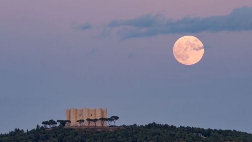 Lua cheia do Caçador nascendo atrás do Castel del Monte em Andria, Itália, em 28 de outubro de 2023