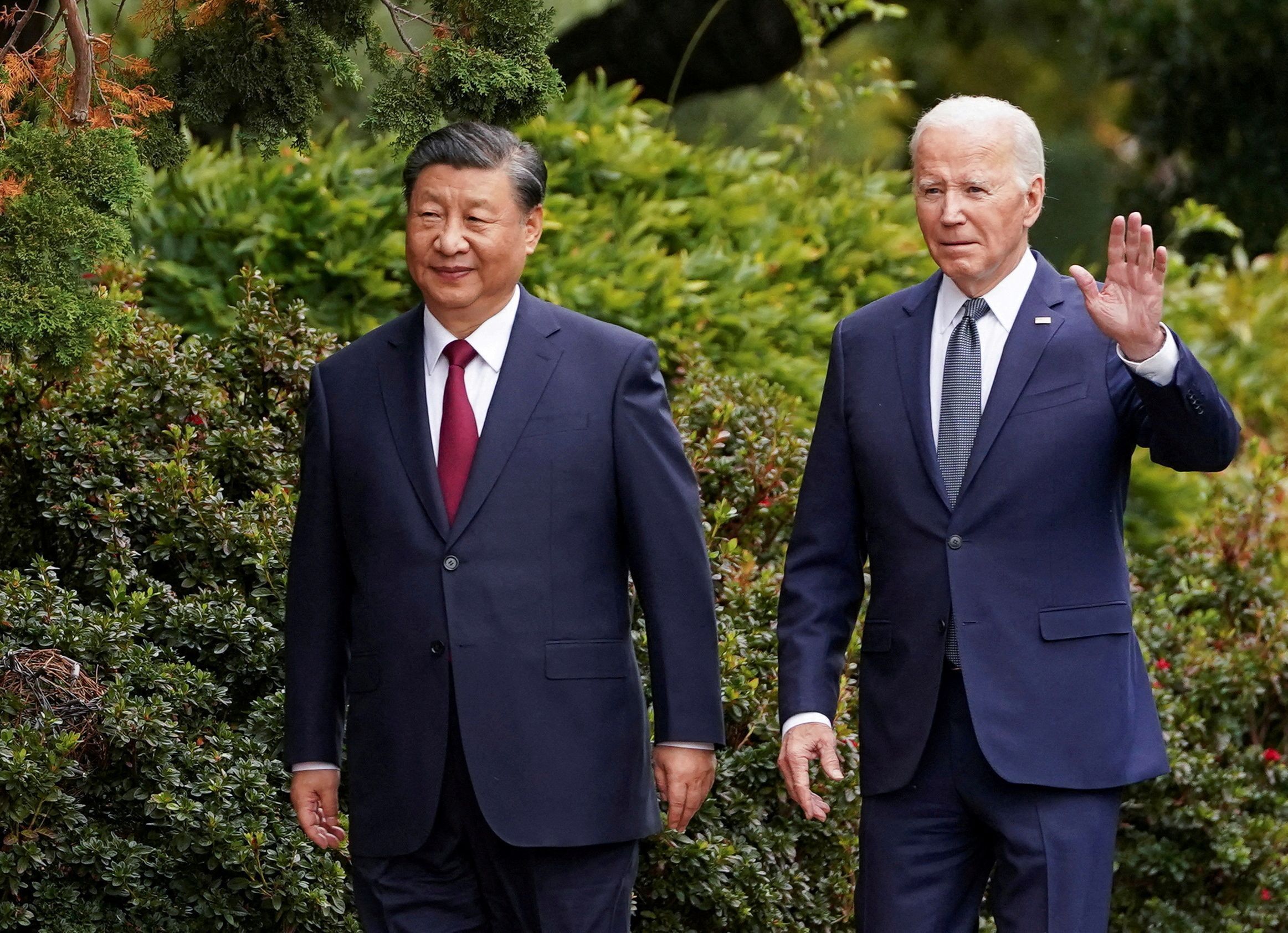 O presidente dos EUA, Joe Biden, acena enquanto caminha com o presidente chinês, Xi Jinping, na propriedade Filoli, à margem da cúpula da Cooperação Econômica Ásia-Pacífico (APEC), em Woodside, Califórnia, EUA