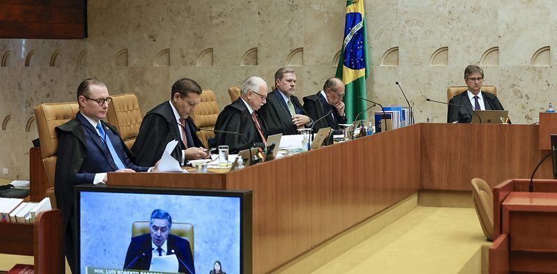 Da esquerda para a direita: os ministros do STF Cristiano Zanin, Nunes Marques, Edson Fachin, Dias Toffoli e Gilmar Mendes, e o procurador-geral da República, Paulo Gonet, em sessão no Supremo; no monitor, o presidente do STF, Luís Roberto Barroso