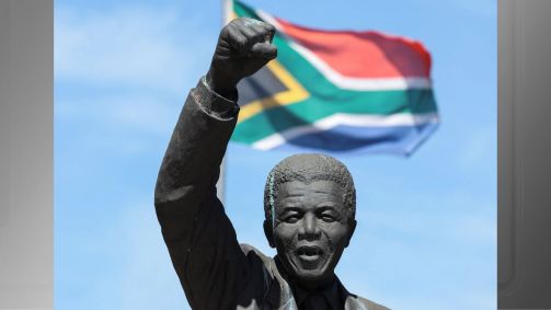 Bandeira da África do Sul atrás de estátua de Nelson Mandela na Cidade do Cabo