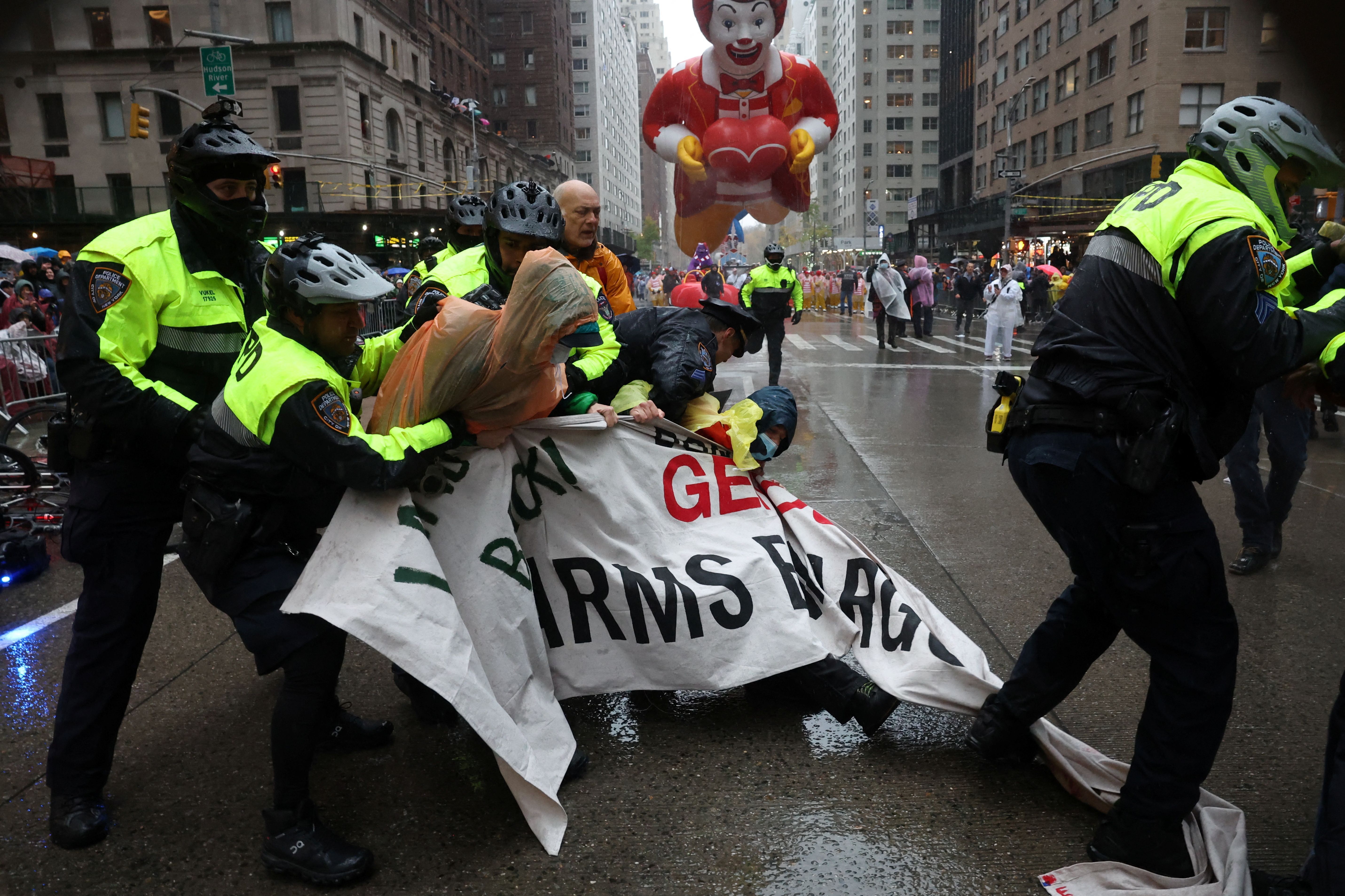 Policiais entram em confronto com manifestantes durante a 98ª Parada do Dia de Ação de Graças da Macy's na cidade de Nova York, EUA