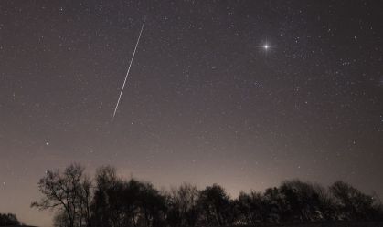 Um meteoro de uma das chuvas de meteoros Taurídeos atravessa o céu noturno sobre a região de Brkini, na Eslovênia, em novembro de 2015