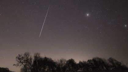 Um meteoro de uma das chuvas de meteoros Taurídeos atravessa o céu noturno sobre a região de Brkini, na Eslovênia, em novembro de 2015