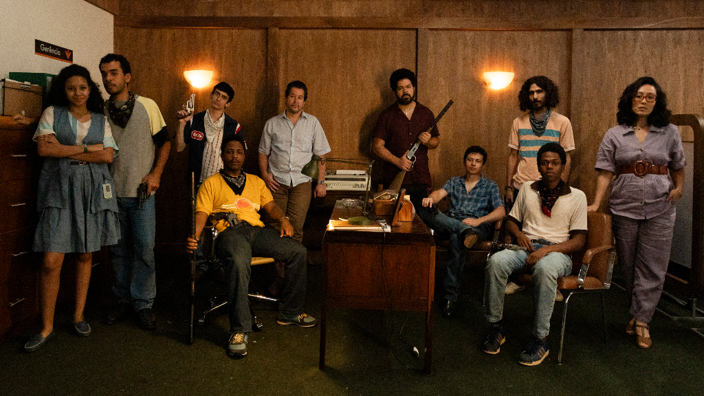 (Da esquerda para direita) Em pé: Laura Luz, Matheus Macena, Vinicius Marinho, Murilo Benício, Robson Nunes, Vertin Moura e Yohama Eshima. Sentados: Christian Malheiros, Ariclenes Barroso e Shaolin. • Divulgação