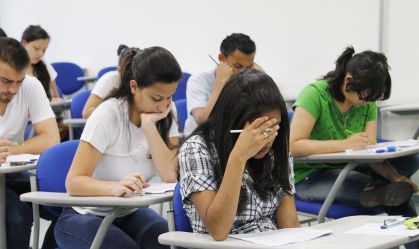 A imagem mostra uma sala de aula com estudantes fazendo uma prova de vestibular