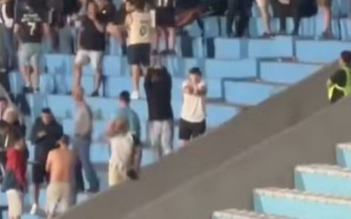 Torcedor do Botafogo fazendo sinal de mãos algemadas em jogo no Uruguai