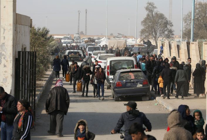 Pessoas deslocadas que fugiram da zona rural de Aleppo passam por carros em Tabqa, Síria 4/12/2024 REUTERS/Orhan Qereman • Reprodução/Reuters