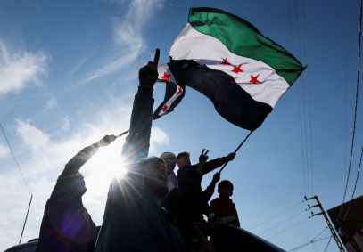Uma pessoa ergue a bandeira da oposição Síria depois que rebeldes anunciaram que depuseram o presidente Bashar al-Assad, no Líbano, em 8 de dezembro de 2024.
