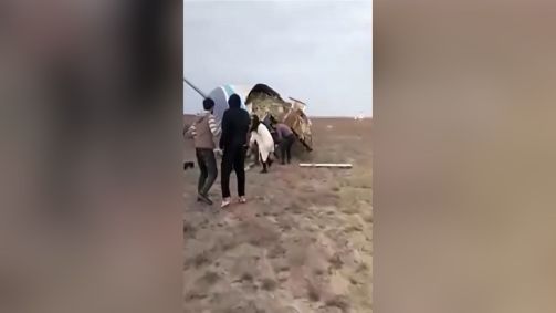 Imagem tirada de vídeo mostra sobreviventes saindo de destroços de avião que caiu no Cazaquistão