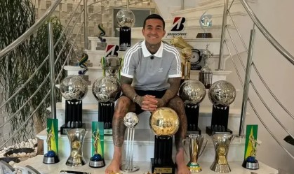 Dudu posou ao lado de troféus