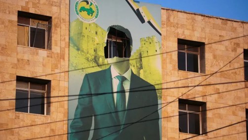 Um cartaz danificado do presidente sírio Bashar al-Assad em Aleppo