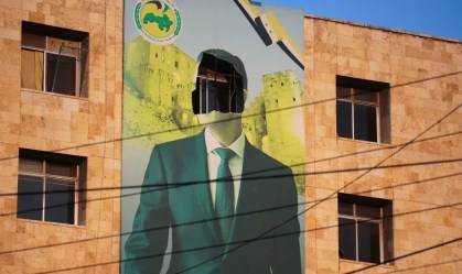 Um cartaz danificado do presidente sírio Bashar al-Assad em Aleppo