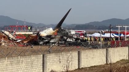Avião destruído com socorristas do lado direito da aeronave