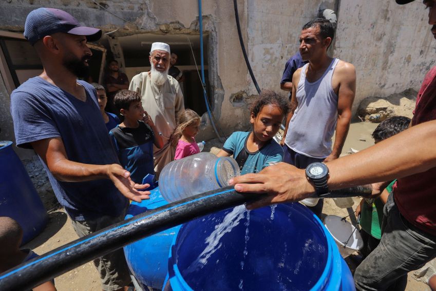 Palestinos coletam água em meio à escassez enquanto o conflito entre Israel e o Hamas continua, em Khan Younis, no sul da Faixa de Gaza. •