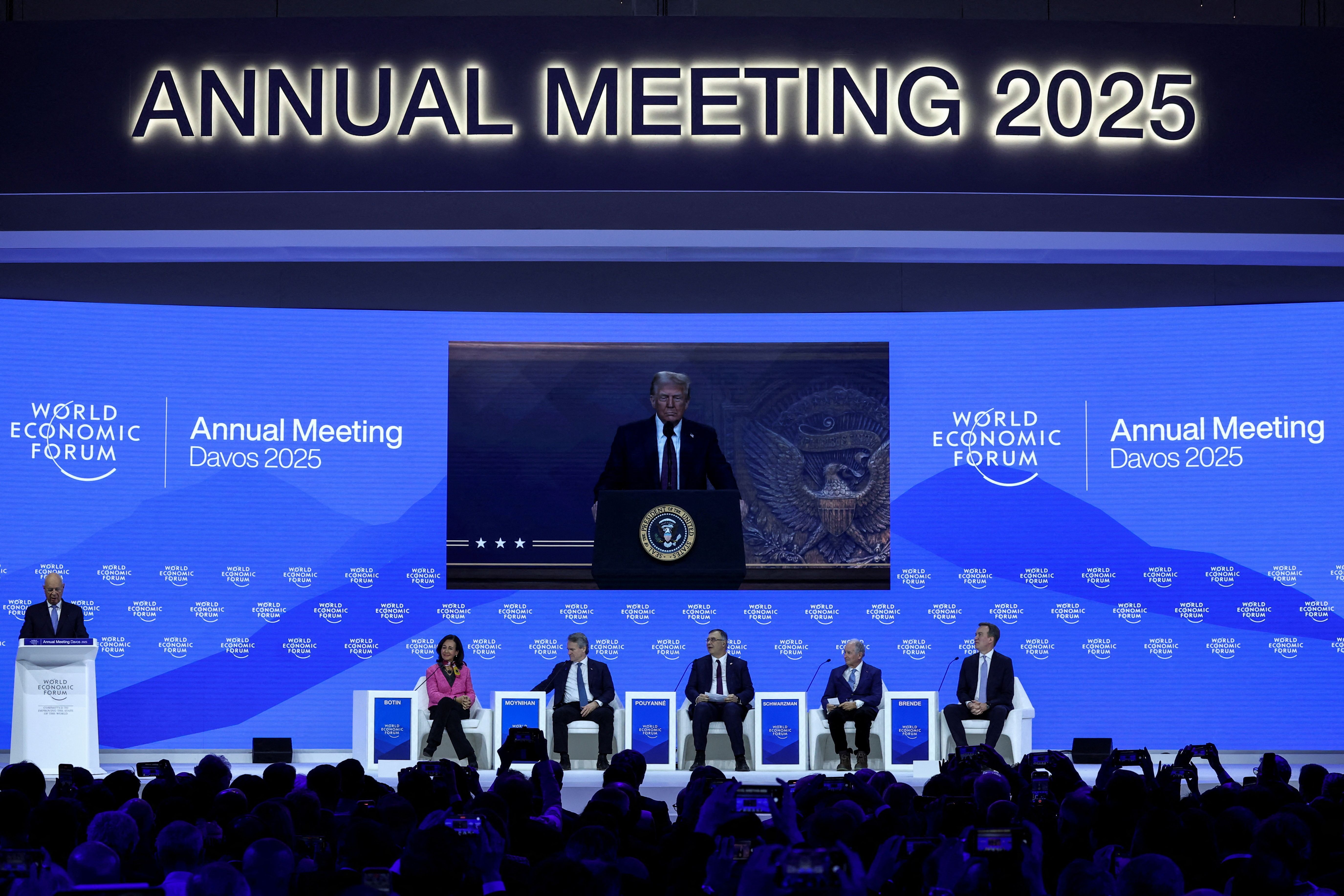 Chairman Klaus Schwab fala enquanto o presidente dos EUA, Donald Trump, aparece em uma tela durante a 55ª reunião anual do Fórum Econômico Mundial em Davos. • 23/01/2025 REUTERS/Yves Herman