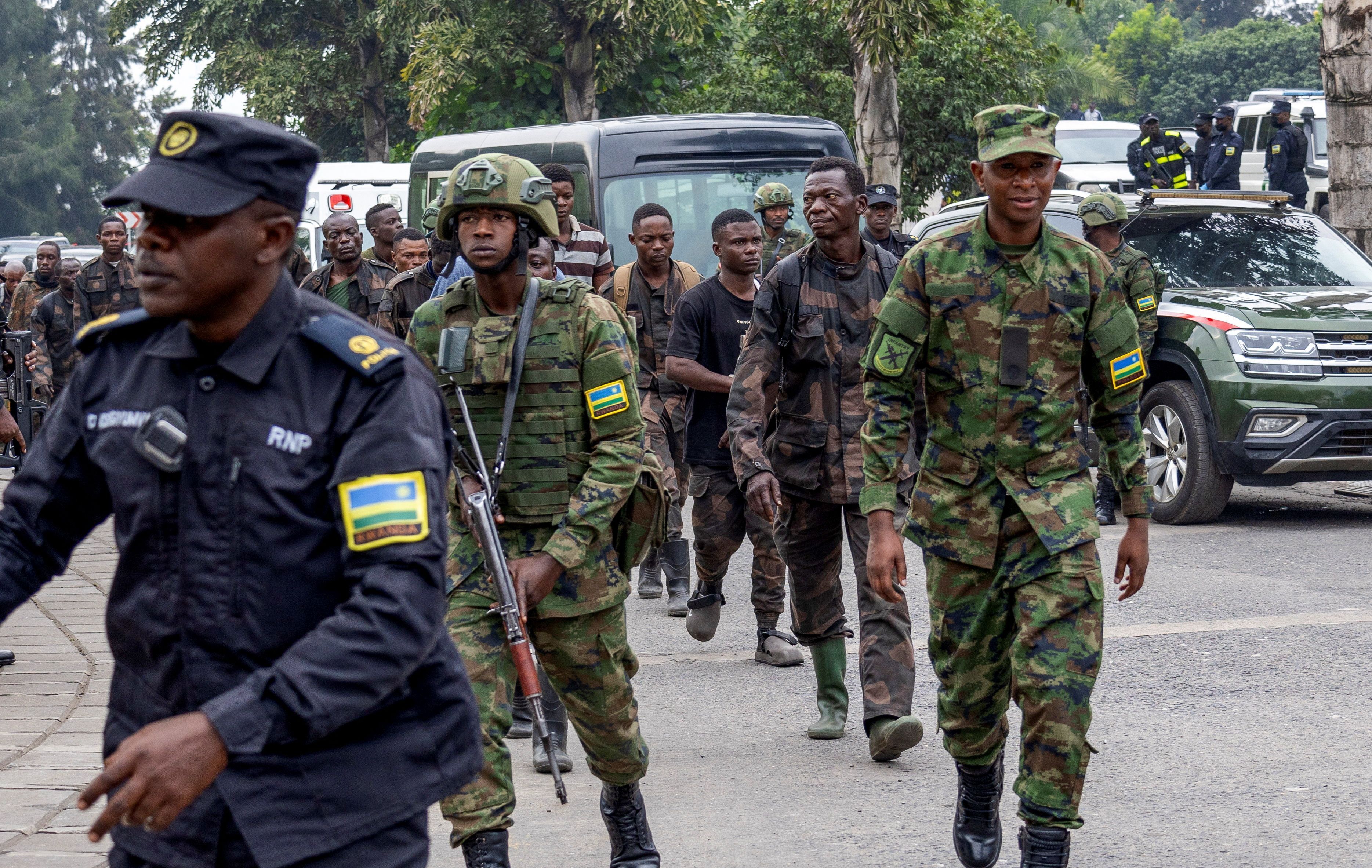 Forças de segurança de Ruanda escoltam soldados das Forças Armadas da República Democrática do Congo que se renderam na cidade congolesa de Goma